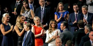 Audience members applauding at a formal indoor event