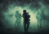 Soldiers move through dense smoke in a forest