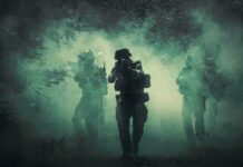 Soldiers move through dense smoke in a forest