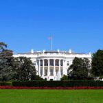 The White House facade with flag and gardens