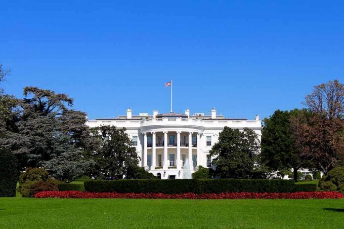 shutterstock_1051409453 The White House facade with flag and gardens