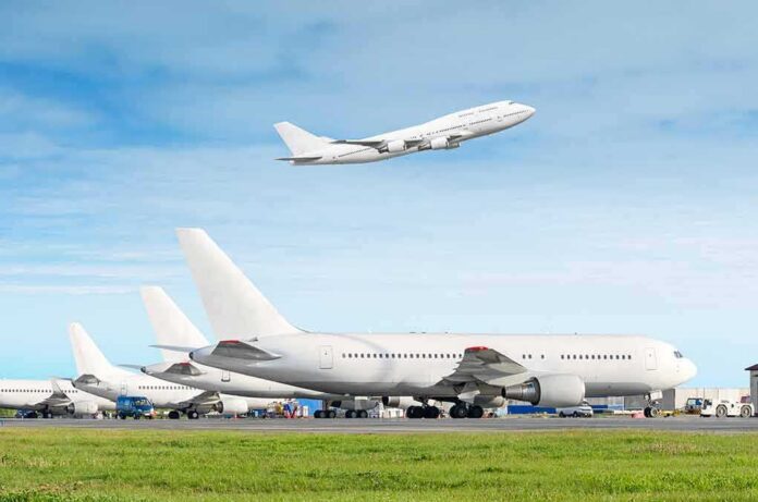 Commercial airplanes at airport with one taking off