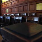 Empty wooden jury box with numbered chairs