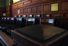 Empty wooden jury box with numbered chairs