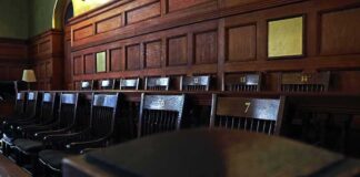 Empty wooden jury box with numbered chairs