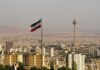 Iranian flag over Tehran skyline with Milad Tower