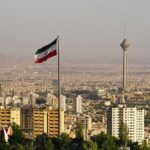 Iranian flag over Tehran skyline with Milad Tower