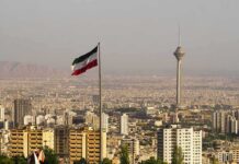Iranian flag over Tehran skyline with Milad Tower