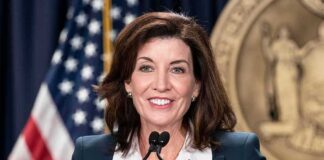woman speaking at a podium with microphones