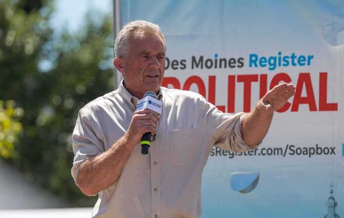Man speaking on an outdoor stage with a microphone