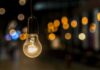 Light bulb hanging with warm bokeh lights in background