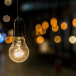 Light bulb hanging with warm bokeh lights in background