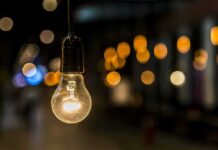 Light bulb hanging with warm bokeh lights in background