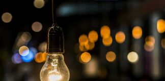 Light bulb hanging with warm bokeh lights in background
