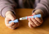 Hands holding an Ozempic injection pen.