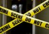 Yellow crime scene tape crossing a doorway