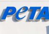 Blue PETA sign on a white wall