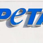 Blue PETA sign on a white wall