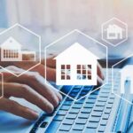 Hands typing on laptop with real estate house icons overlay