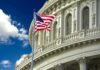 American flag waving before a neoclassical government building