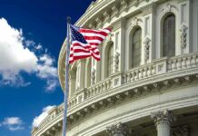 American flag waving before a neoclassical government building