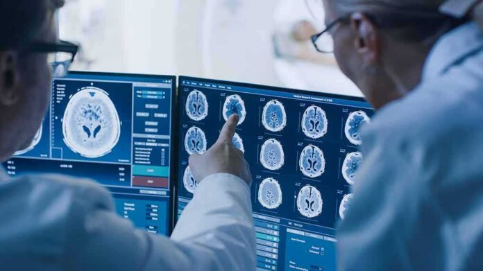 shutterstock_1243951690 Doctors reviewing brain MRI scans on multiple monitors