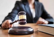 Judge's gavel striking sound block on courtroom desk