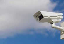security camera mounted on a pole against blue sky