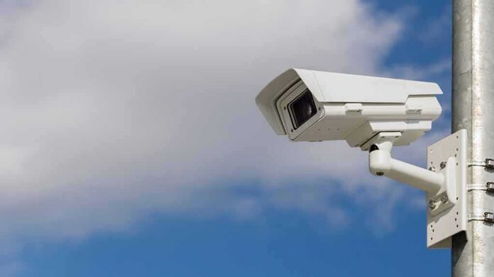 security camera mounted on a pole against blue sky