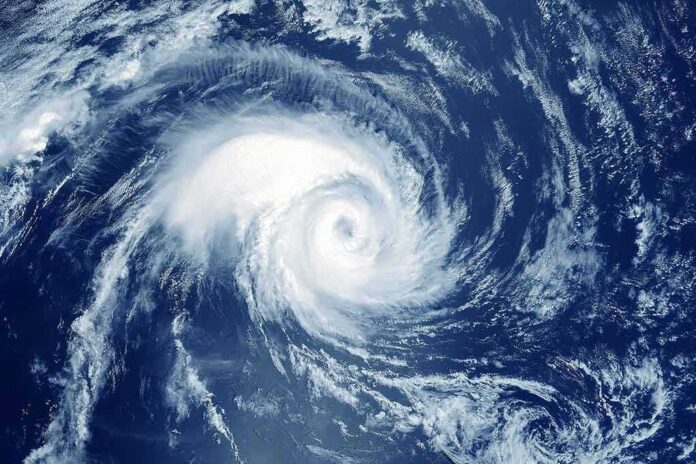 shutterstock_1603937461 Hurricane swirling over the ocean from above