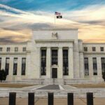 Neoclassical government building with American flag at sunset