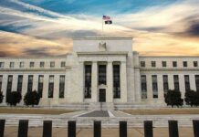 Neoclassical government building with American flag at sunset