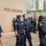Teddy Williams and Carlos Hyde among police officers in riot gear outside police headquarters