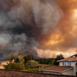 Wildfire smoke billows over suburban houses