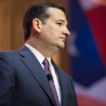 Ted Cruz in profile wearing a suit and tie on stage