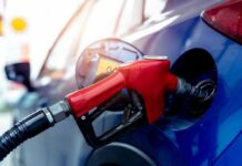 Red gasoline nozzle fueling a blue car