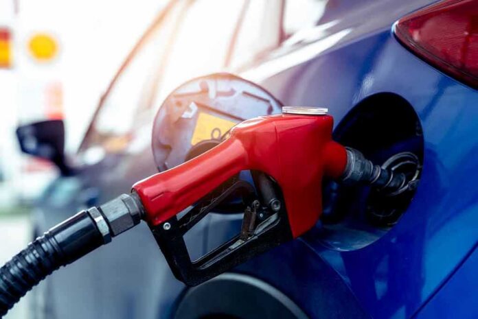 Red gasoline nozzle fueling a blue car