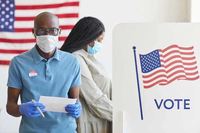shutterstock_1810359391 Voters wearing masks at a polling station