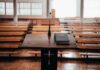 Podium with microphone and book in empty lecture hall