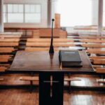 Podium with microphone and book in empty lecture hall