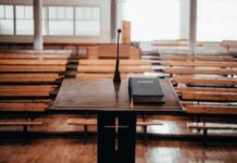 Podium with microphone and book in empty lecture hall