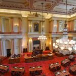 Legislative chamber with red carpet and chandeliers