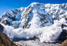 Snow avalanche sweeping down a rugged mountain