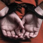 person in handcuffs with hands behind back