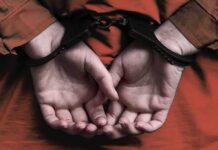 person in handcuffs with hands behind back