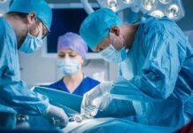 Surgeons perform an operation in a hospital operating room