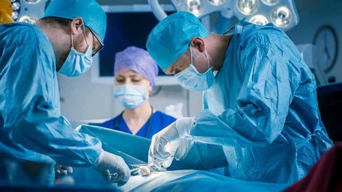 Surgeons perform an operation in a hospital operating room