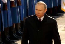 Vladimir Putin walking past a guard of honor