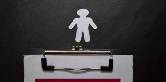 clipboard with missing person notice and paper cutout figure