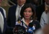 Woman speaking to reporters at a press scrum